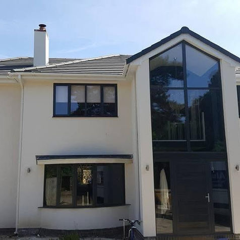 Modern white house with dark-framed windows and glass entrance