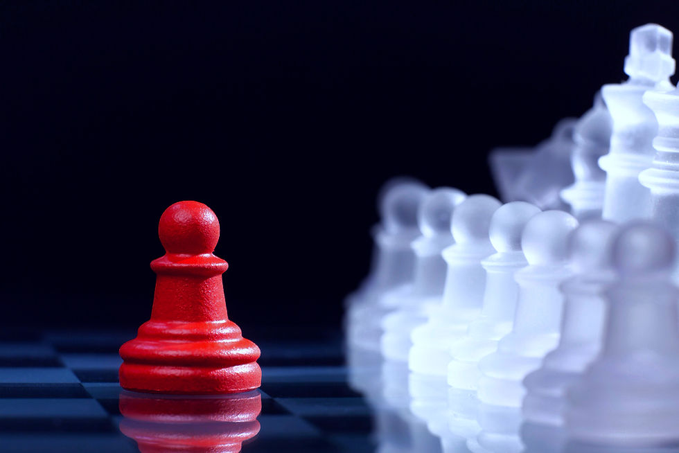 Red chess pawn stands alone facing numerous clear opposing pieces.