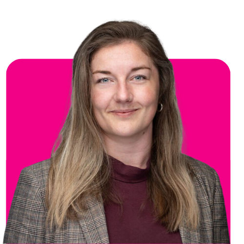 Team member with light brown hair, smiling in a blazer