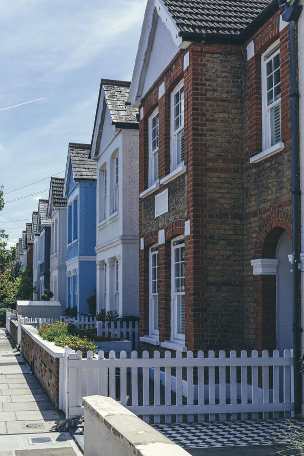 Row of colorful houses with picket fence on sunny day HOME
