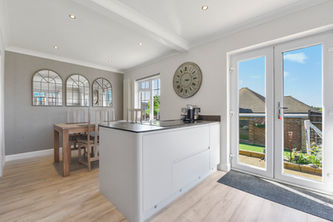 Modern kitchen with island, table, mirrors and clock Home. Interior design and decor