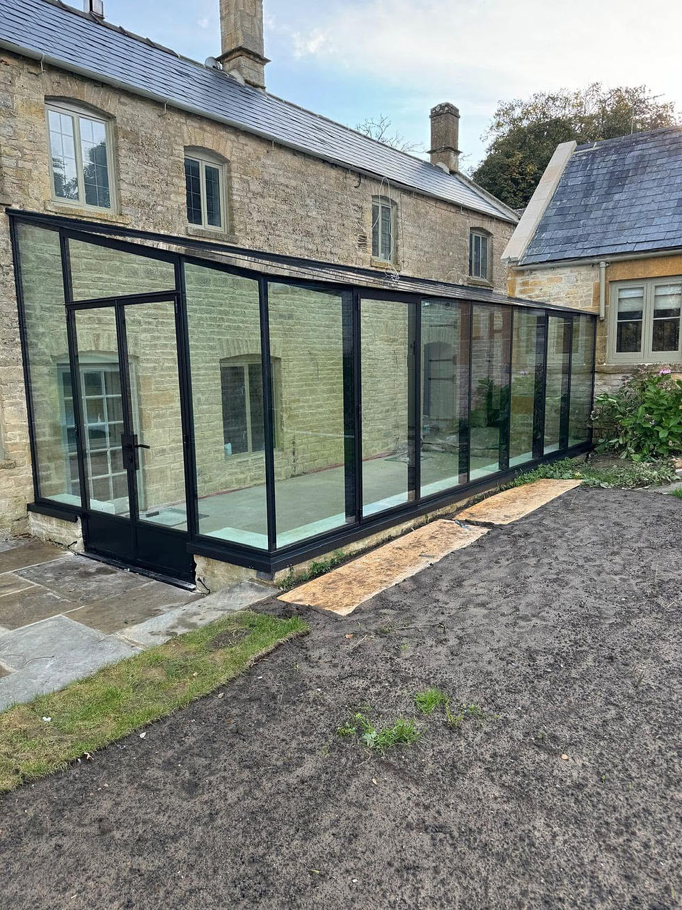 Black-framed glass extension on stone building