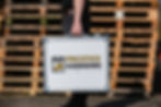 Person holding a case with Prestige Guarding Limited logo
