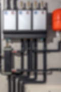 Plumbing system with three white panels, red and blue circles, and black pipes.