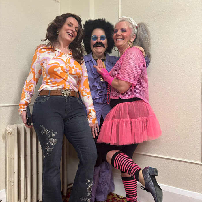 Three people in fun 70s disco and 80s themed costumes.