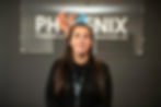 Woman smiles in front of PHOENIX PLUMBING & SOLUTIONS LTD sign ABOUT US