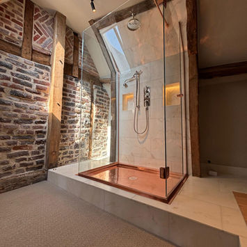 Modern shower with copper base, skylight, exposed beams
