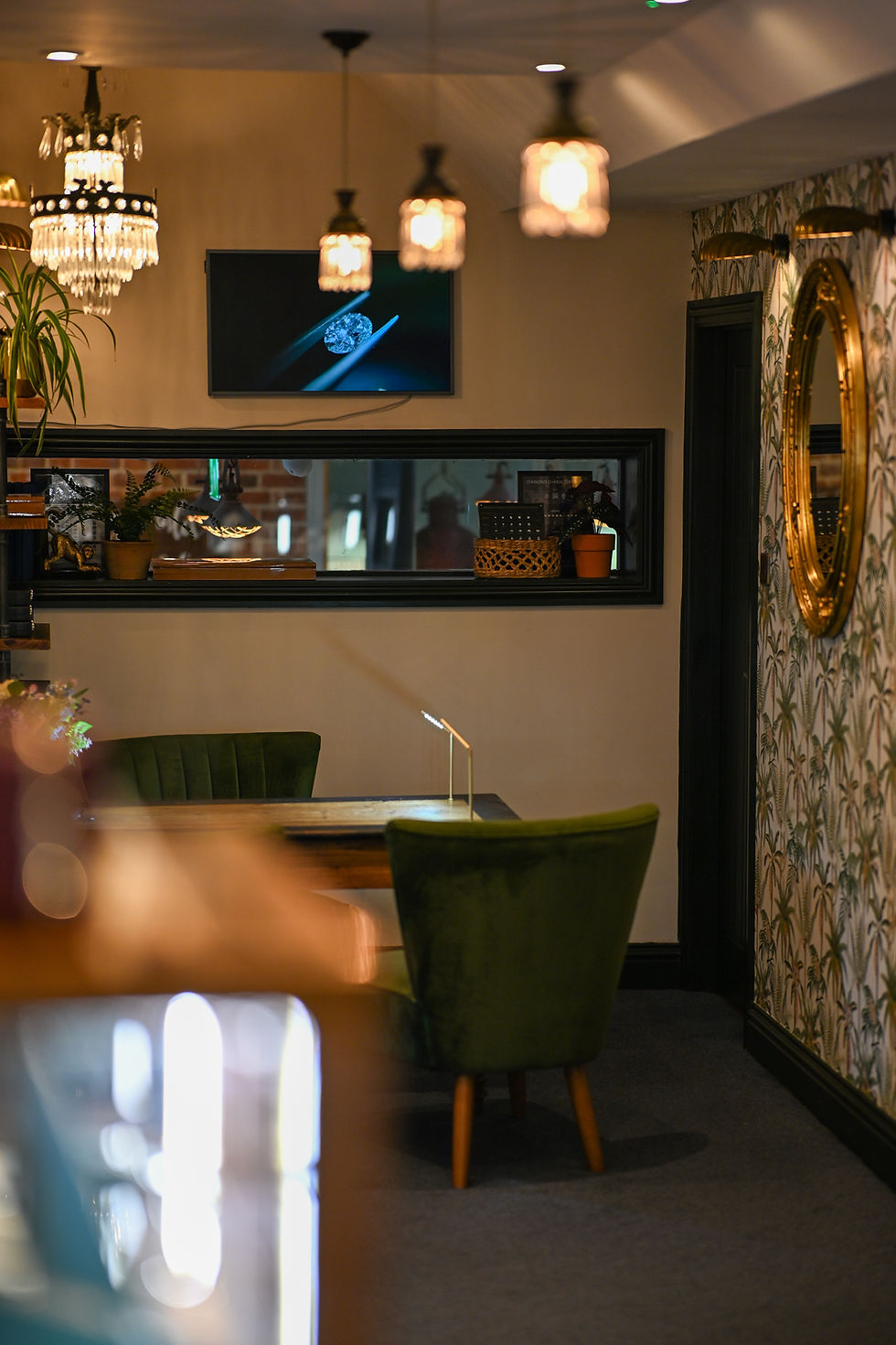 Elegant lounge with green velvet chairs and hanging lamps