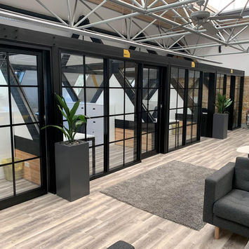 Modern office with glass private rooms and lounge area