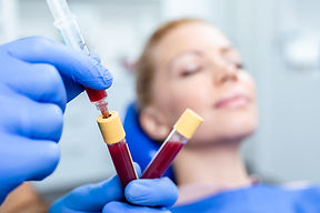 Therapist holds PRP vials in foreground with patient visible in background