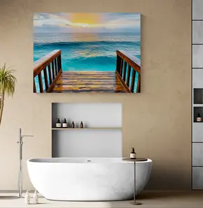 Turquoise ocean-pier gallery-wrapped canvas wall art displayed above a freestanding white soaking tub in a modern spa bathroom, positioned away from direct shower spray among warm neutral walls, gray tile, open shelving and a turquoise planter.