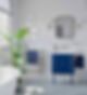 Bright bathroom featuring a blue vanity, green plant, and a freestanding tub