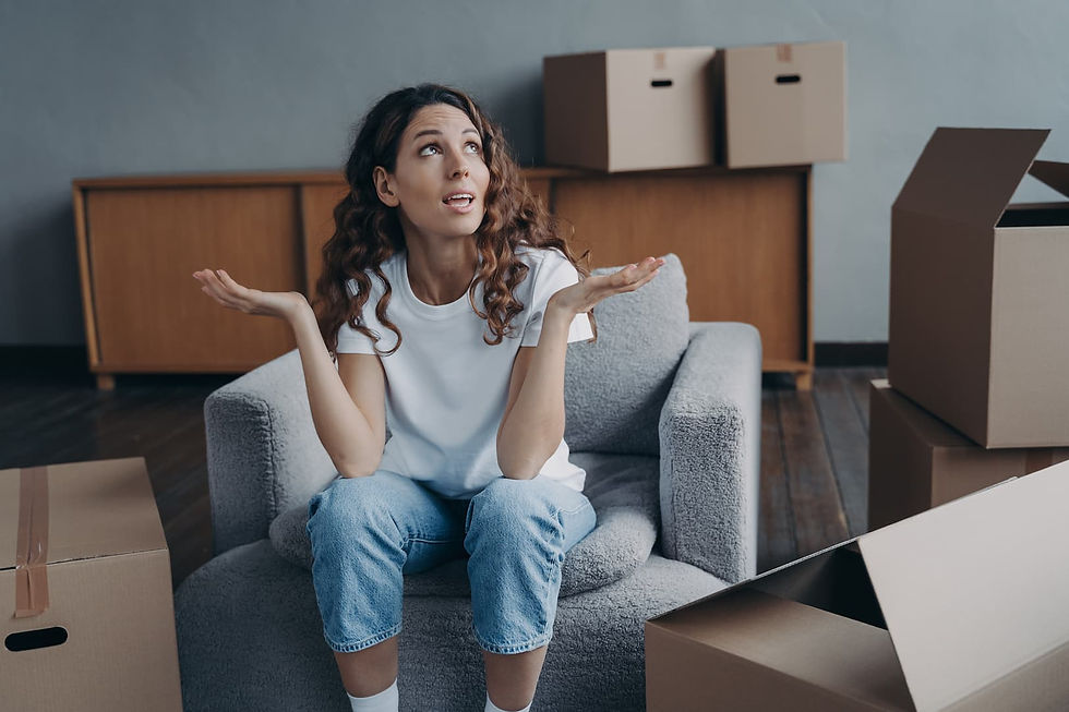 Woman sitting among moving boxes and considering her options for a long-distance move.