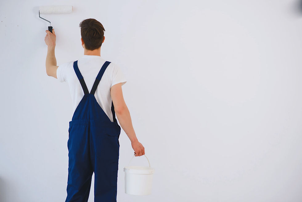 Interior house painter in Chicago area applying fresh white paint with roller — professional painting services.