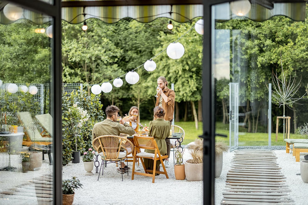 Family enjoying a cozy backyard makeover with DIY string lights, gravel patio, and natural wood furniture