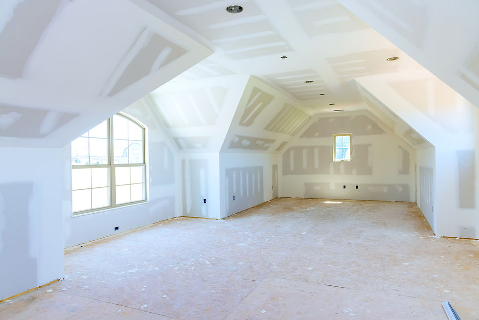 Finished drywall installation in a large attic room with clean seams and corner detailing — ready for priming and painting.