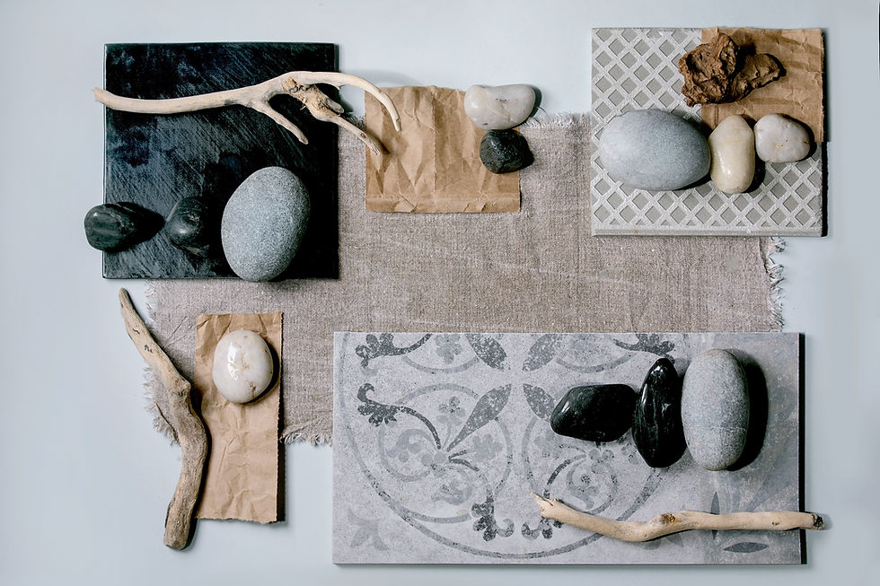 Flat lay of natural materials including stone samples, fabric swatches, and driftwood, arranged for a material mood board in interior design planning.