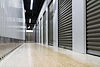 Hallway of secure, climate-controlled storage units with gray roll-up doors, representing moving and storage services