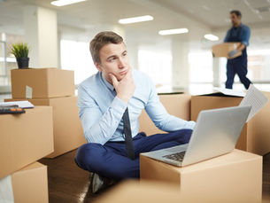 Man comparing moving companies online while preparing for a long-distance move