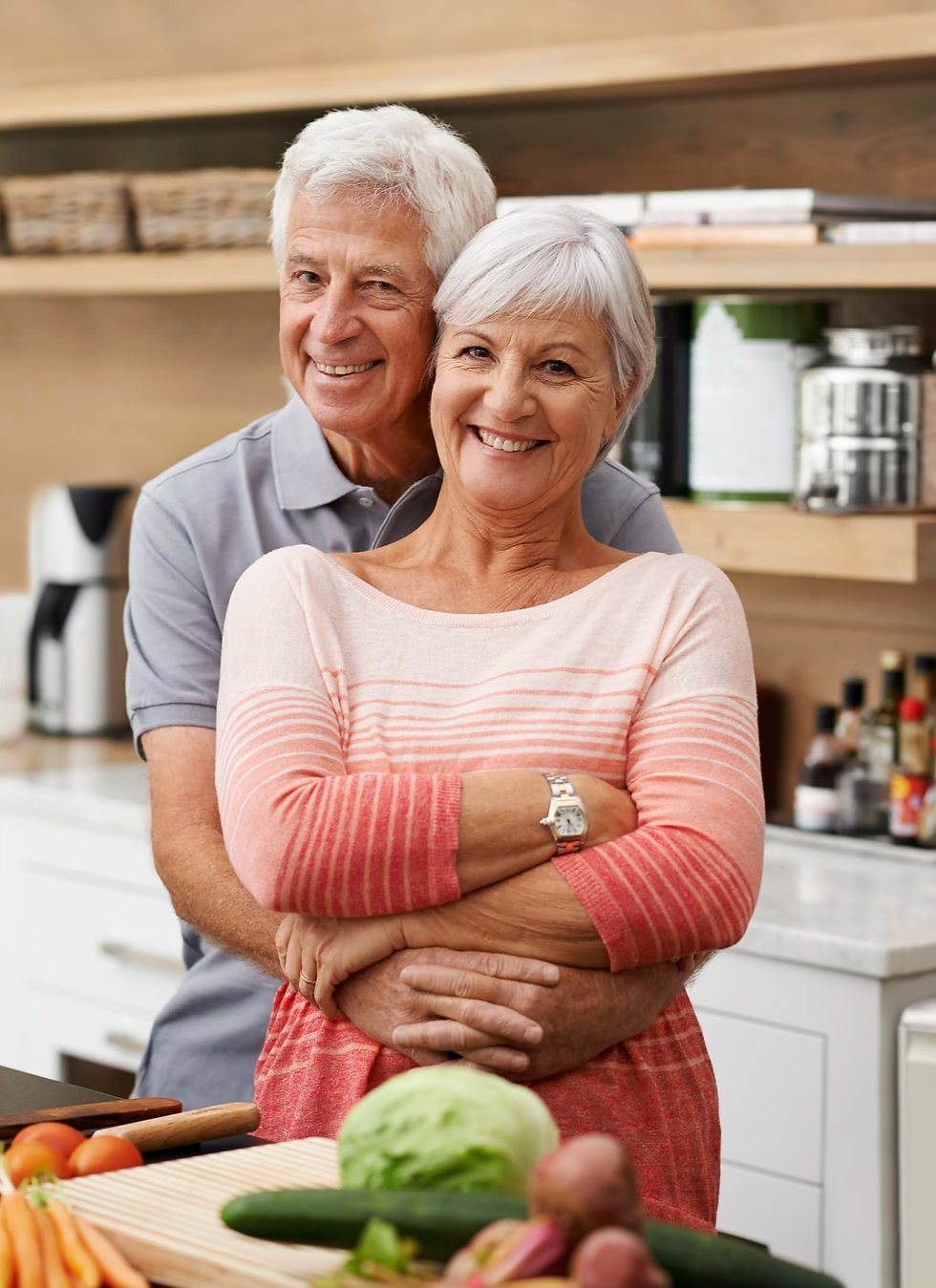 Smiling older couple standing in a bright modern kitchen