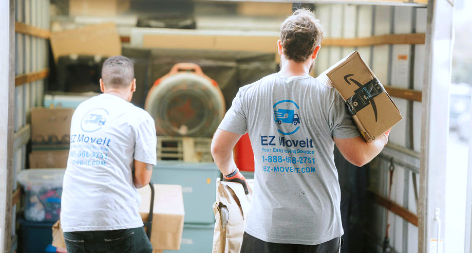 Uniformed EZ MoveIt crew members loading boxes into a truck as part of the 5-step moving process