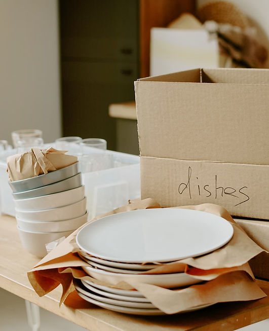 Stack of wrapped plates and a box labeled "dishes", showing proper packing techniques for a local relocation