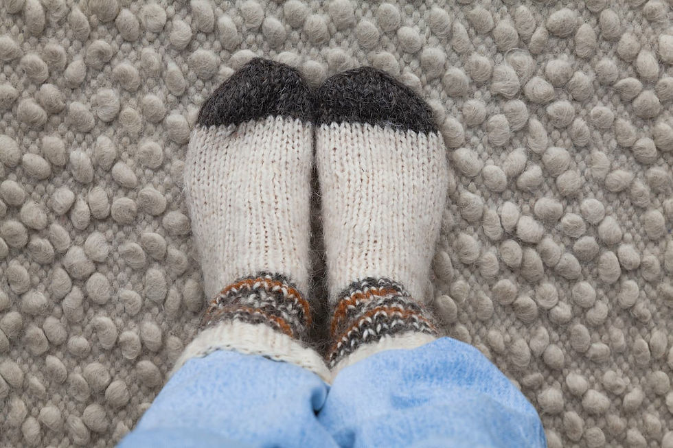 Person wearing warm wool socks trying to warm cold feet in a drafty house.