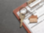 House keys with a home-shaped keychain resting on a clipboard checklist, illustrating PCS move planning