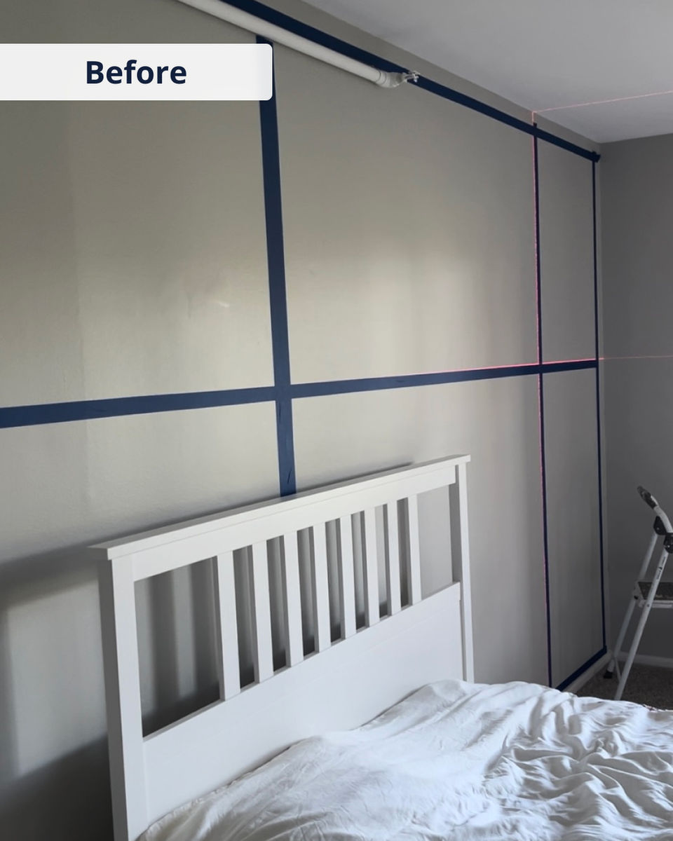 Before photo showing taped wall layout in bedroom, preparing for custom painted accent wall