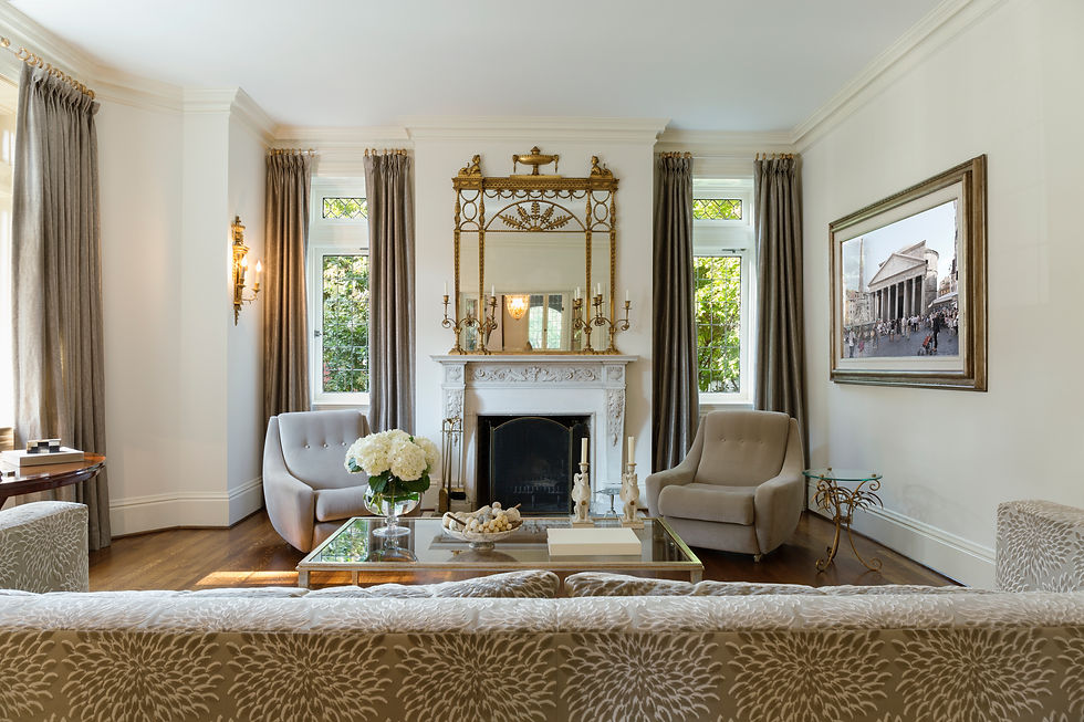 Elegant traditional living room with fireplace, gold mirror, and classic armchairs