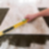 Worker aligning ceramic tile with level — precise tile installation in Kildeer.