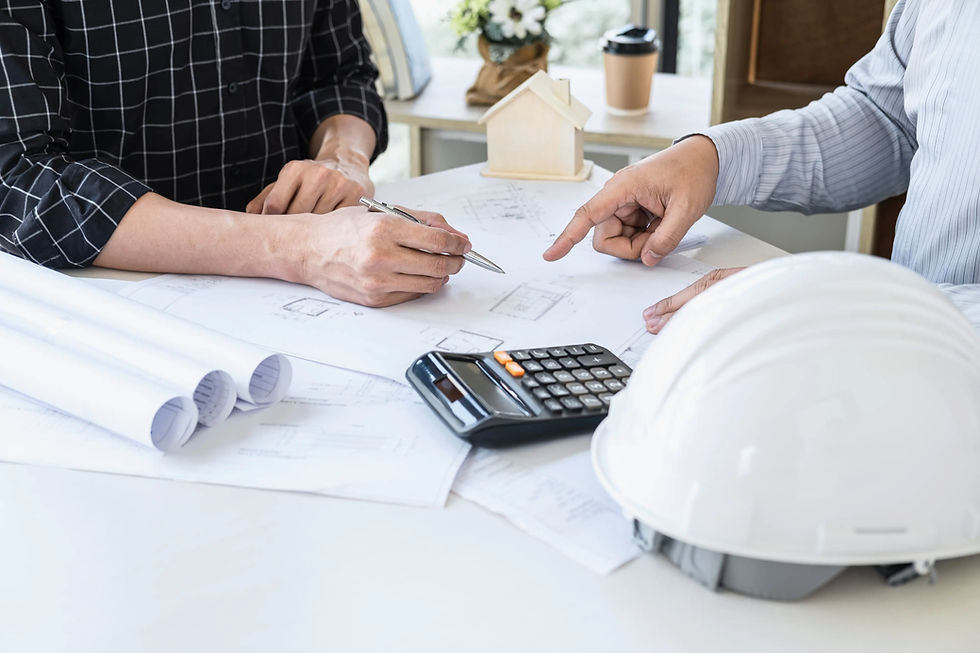 Planning drywall repair costs in Illinois — contractors reviewing blueprints and calculating estimate with tools on desk.