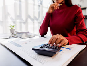 Woman using a calculator to estimate the cost of moving out of Colorado.