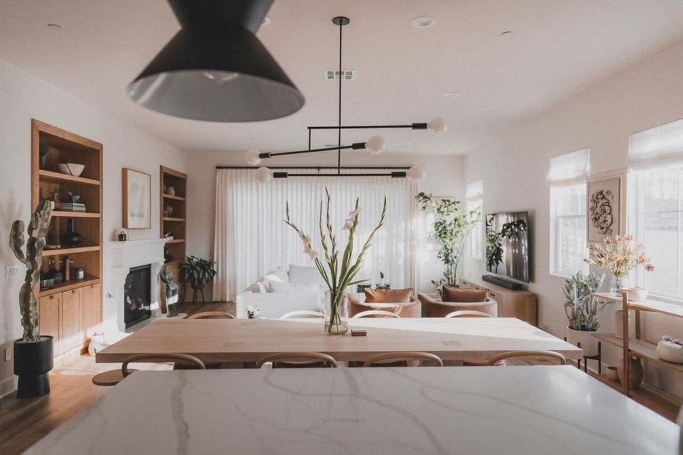 Open-plan kitchen and living area with wood cabinetry, modern light fixture, and a mix of soft and hard materials, demonstrating harmonious design elements.