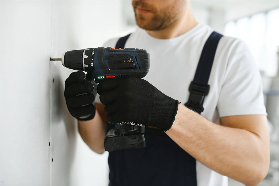 Contractor installing drywall with drill and drywall screws