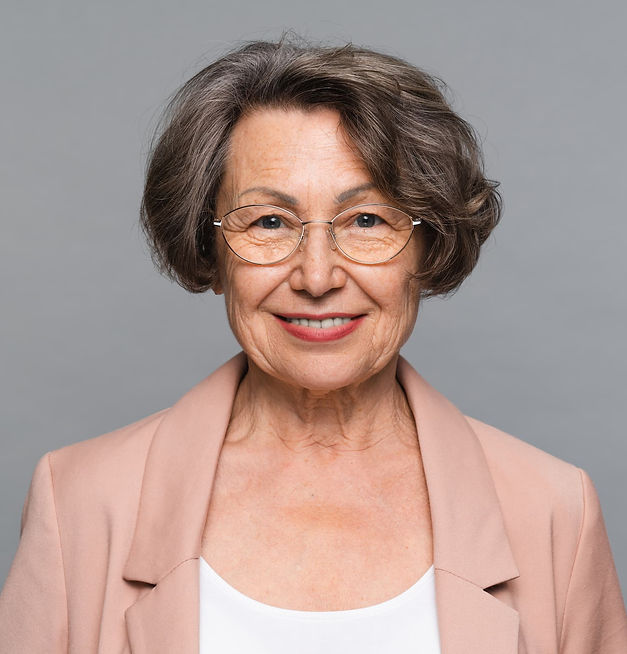 Portrait of an older woman with glasses and a pink blazer — Sarah, happy client from Buffalo Grove after baseboard and crack repairs.