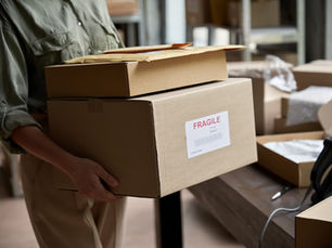 Person holding a self-packed box with a Fragile sticker, illustrating the risks of Released Value Protection (RVP)