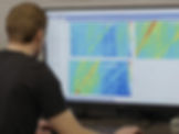 Engenheiro analisando dados experimentais ou simulações em mapas espectrais em uma estação de trabalho