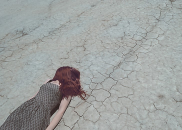 Girl Lying on Dry Ground