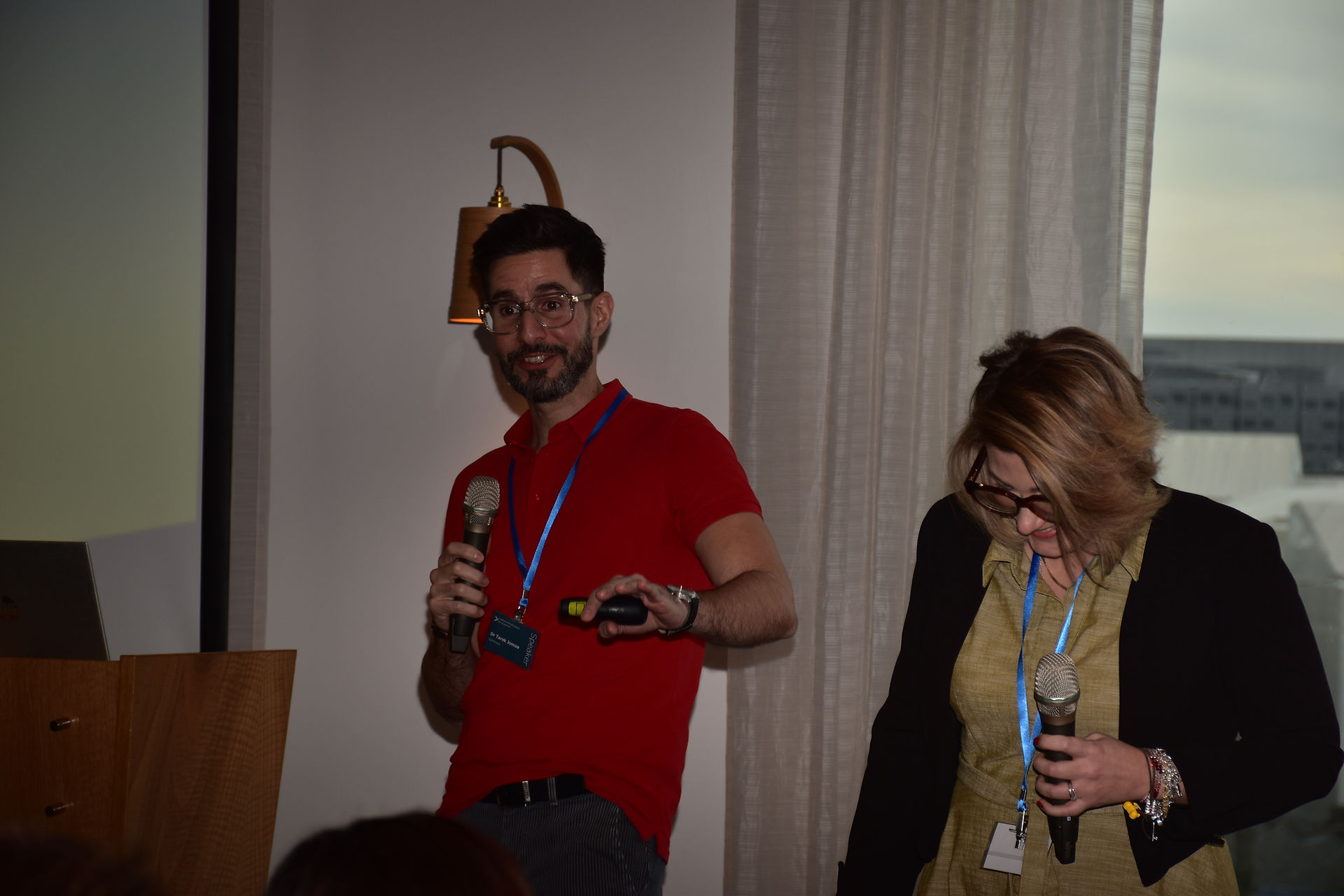 Dr. Tarek Jomaa and Dr. Vanessa Pozzali engaging in a discussion during their presentation at the Women in Leadership Conference, with a professional setting in the background.