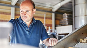 Winzer in der Kellerei bei der Arbeit an Produktionsanlagen für Weinherstellung.