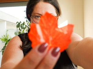 Ragazza con foglia finta autunnale in mano 