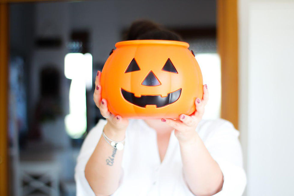 Ragazza con camicia bianca che tiene una finta zucca di Halloween