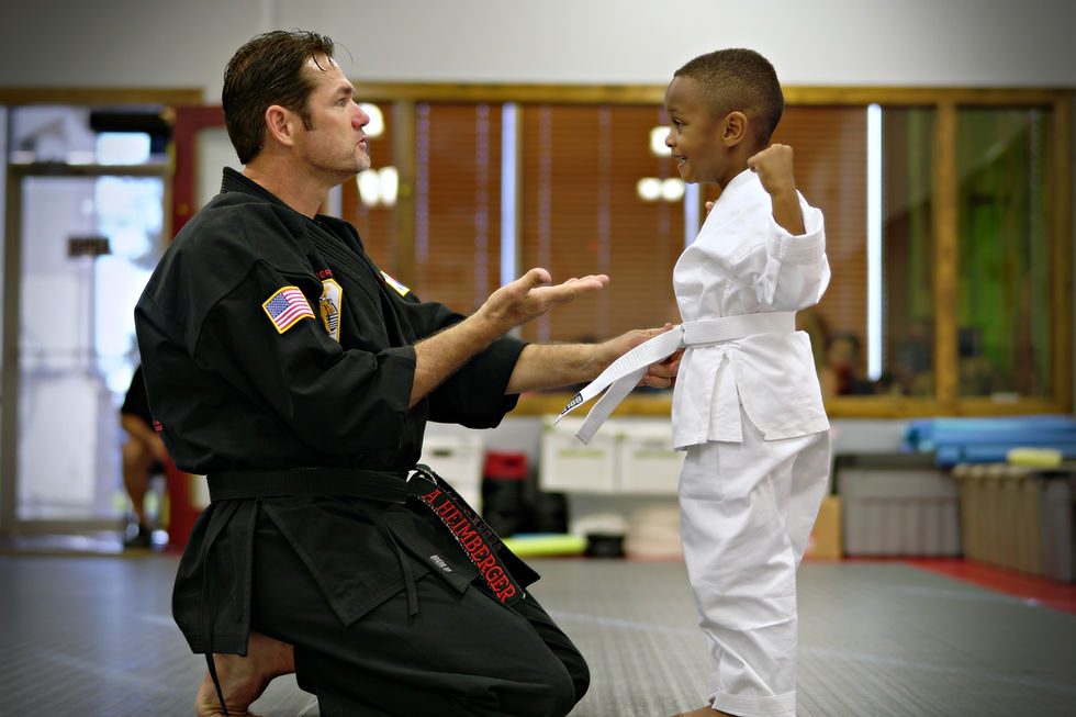 Master Heimberger and young student celebrating him achieving his white belteimberger and little student celibrating him achiving hie white belt