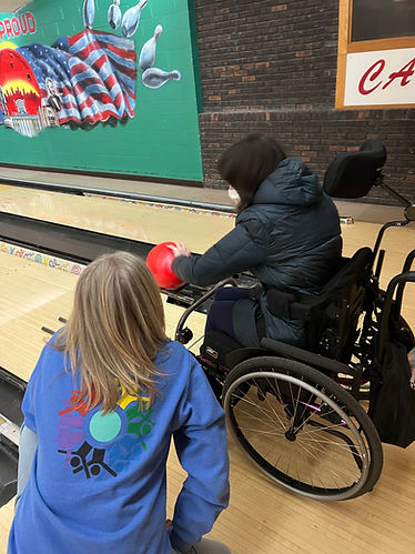 A participant at Metzcor disability day program bowling with a dsp helper.