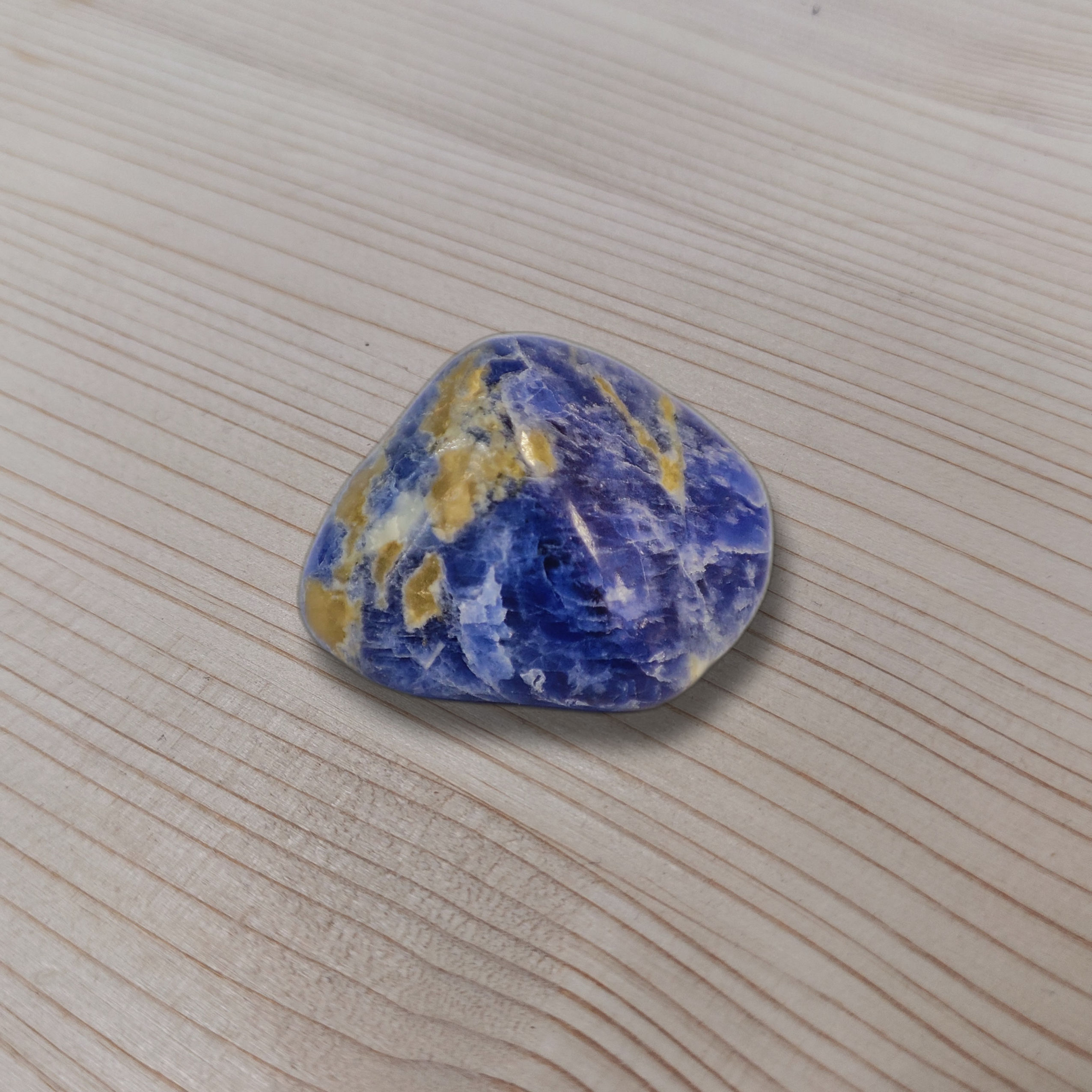 Polierter Sodalith-Trommelstein in tiefem Blau mit weissen Adern