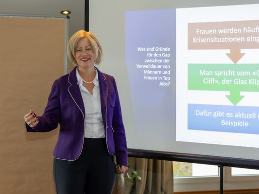 Frau steht und hält Vortrag vor Leinwand 