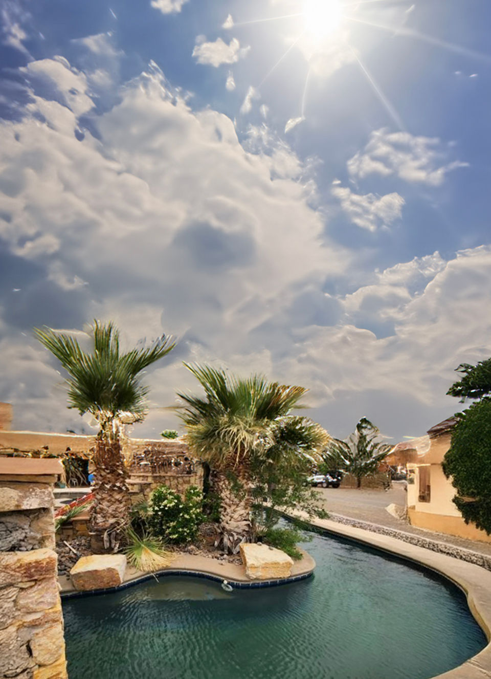 Sunny pool with palm trees and blue sky