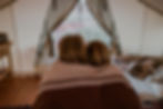 Kids cuddled up and looking out tent at BaseCamp37 glamping property outside Zion National Park