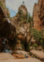 Child at the bottom of towering red sand stone at Water Canyon outside Hildale Utah